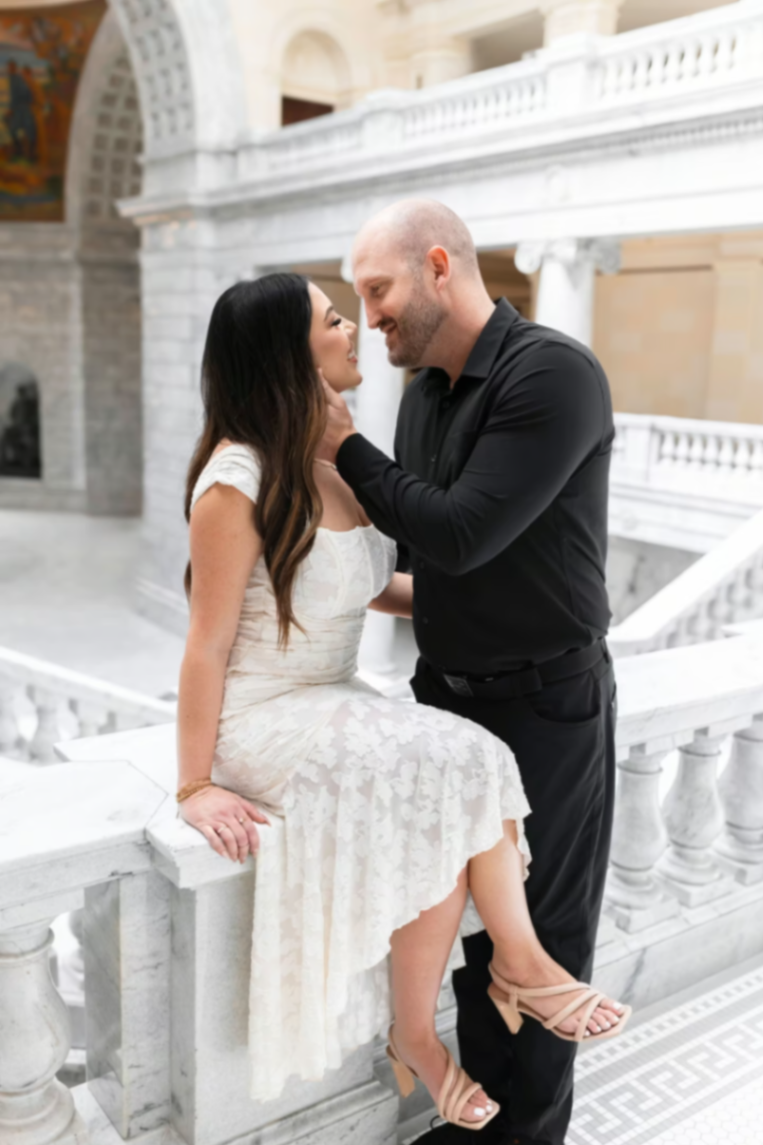 Travis and Chrissy smiling at each other inside the Utah State Capitol.