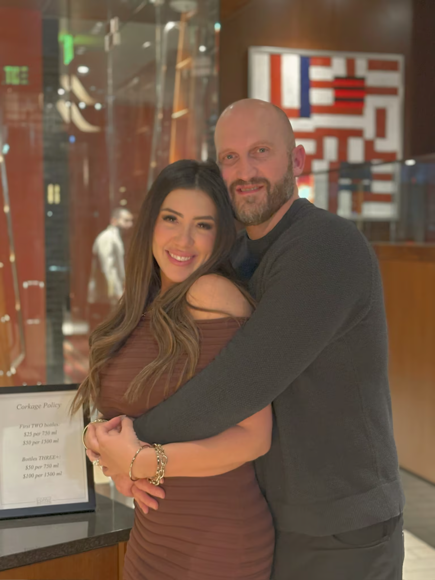 Travis and Chrissy embracing for a warm restaurant portrait.
