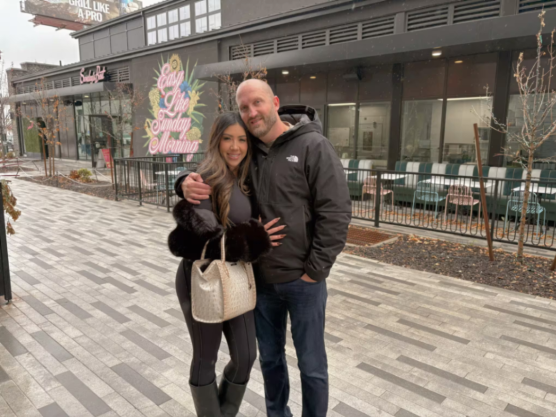 Travis and Chrissy together outside on a snowy city street.