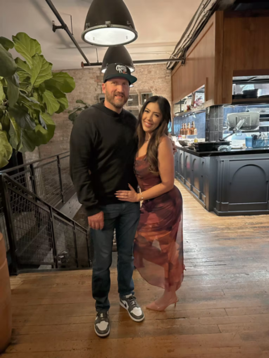Travis and Chrissy dressed up for an evening out in a warmly lit restaurant.