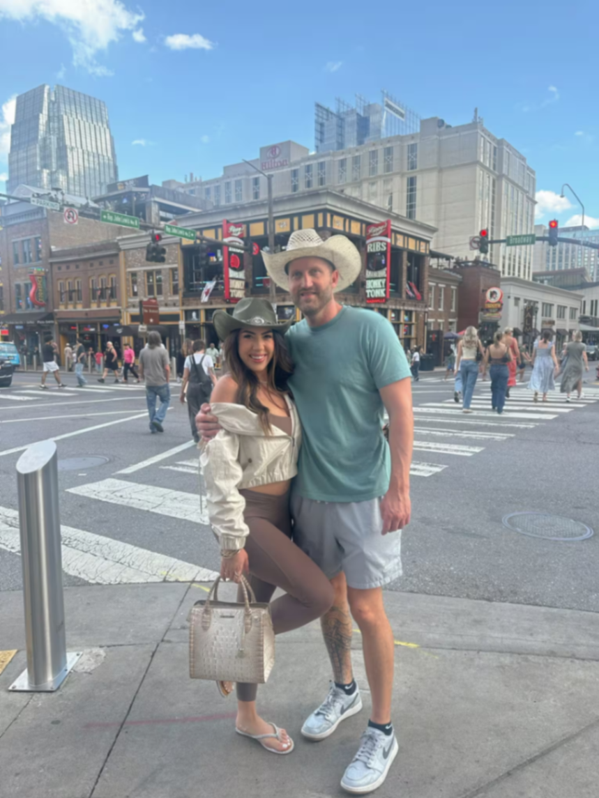 Travis and Chrissy wearing cowboy hats in downtown Nashville.